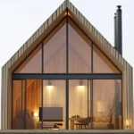 Modern wooden A-frame vacation home with large glass windows in Tanzania, showcasing contemporary architecture and scenic views for a peaceful retreat.